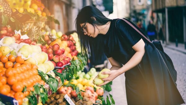 woman buying fruits on street market